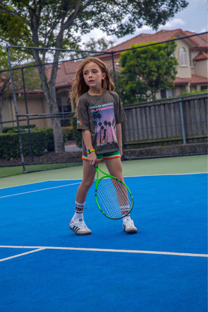 Girls Palm Beach Playground graphic tee by Little Baddie, stylish casual t-shirt for girls aged 5 to 12, front, girl playing tennis